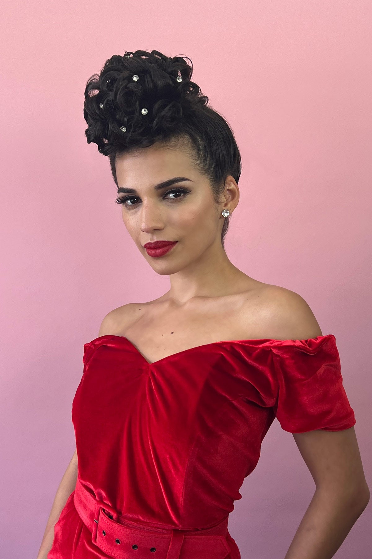 Woman in a red off-shoulder dress with a pink background. Hair poodle clip-in hairpiece bun vintage style 1950s: Lucille chestnut brown 8