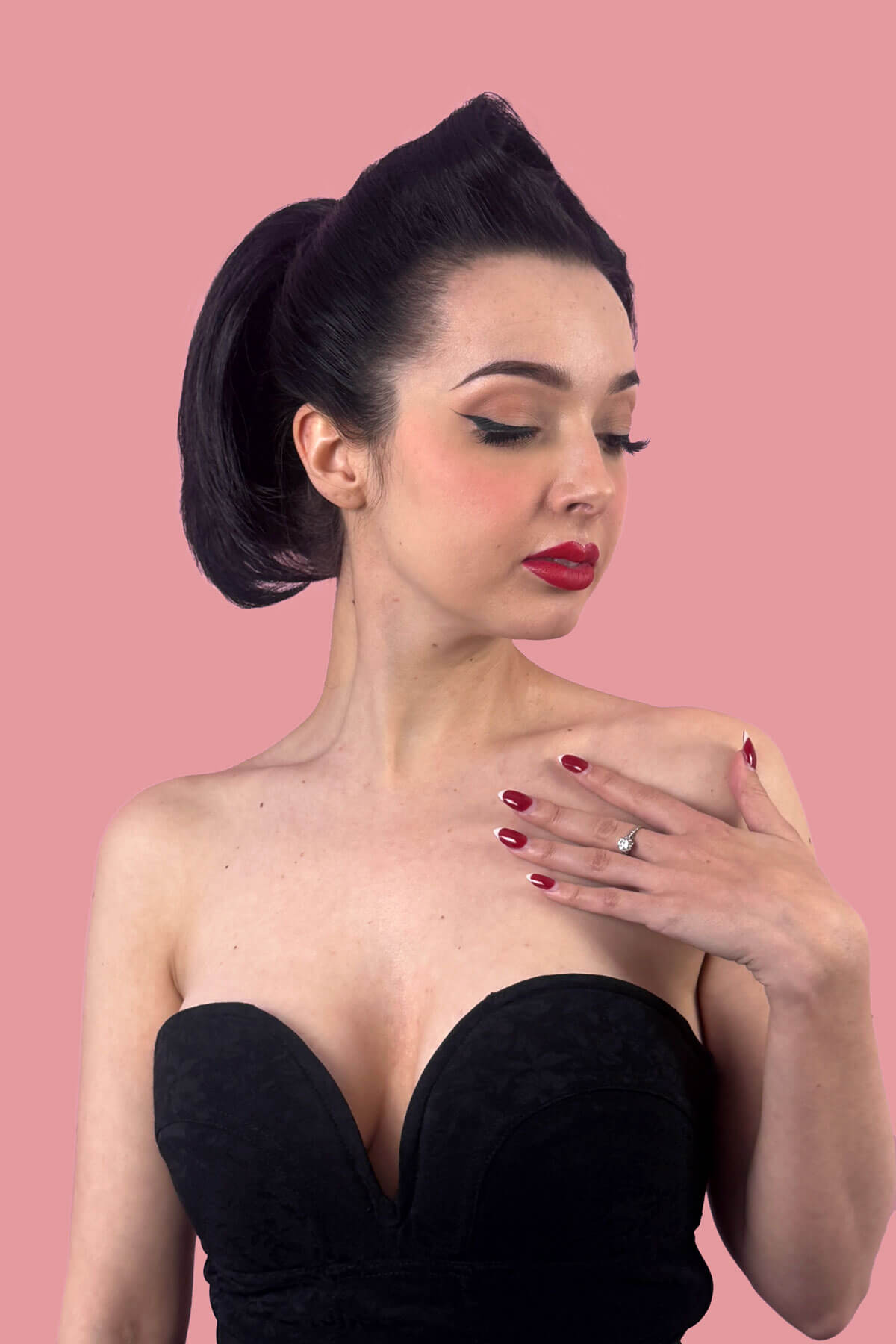 Woman with styled hair, with short ponytail against a pink background. Short beehive ponytail hairpiece: Sherri black 1B