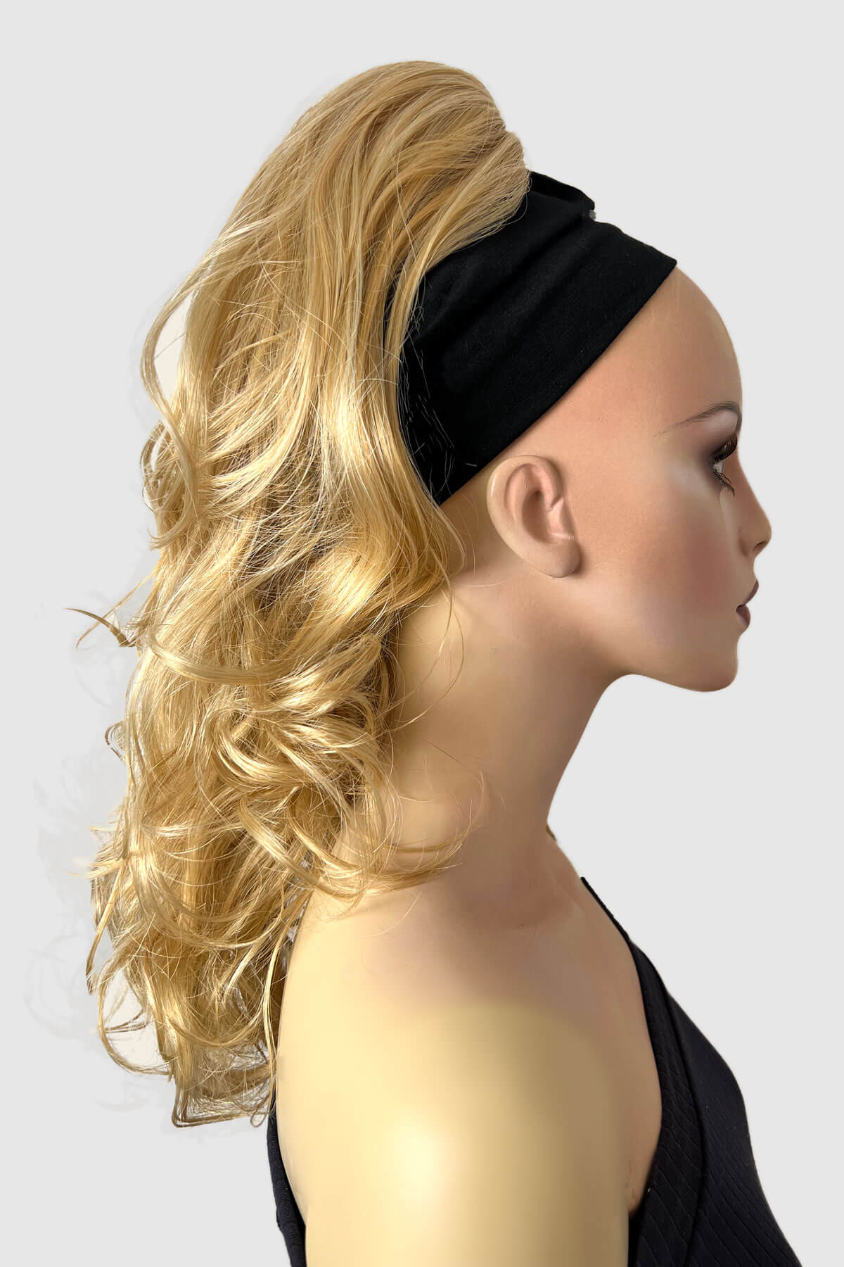 A woman wearing a floral off-shoulder top with a curly ponytail hairpiece extension in dark brown color. blonde LG26