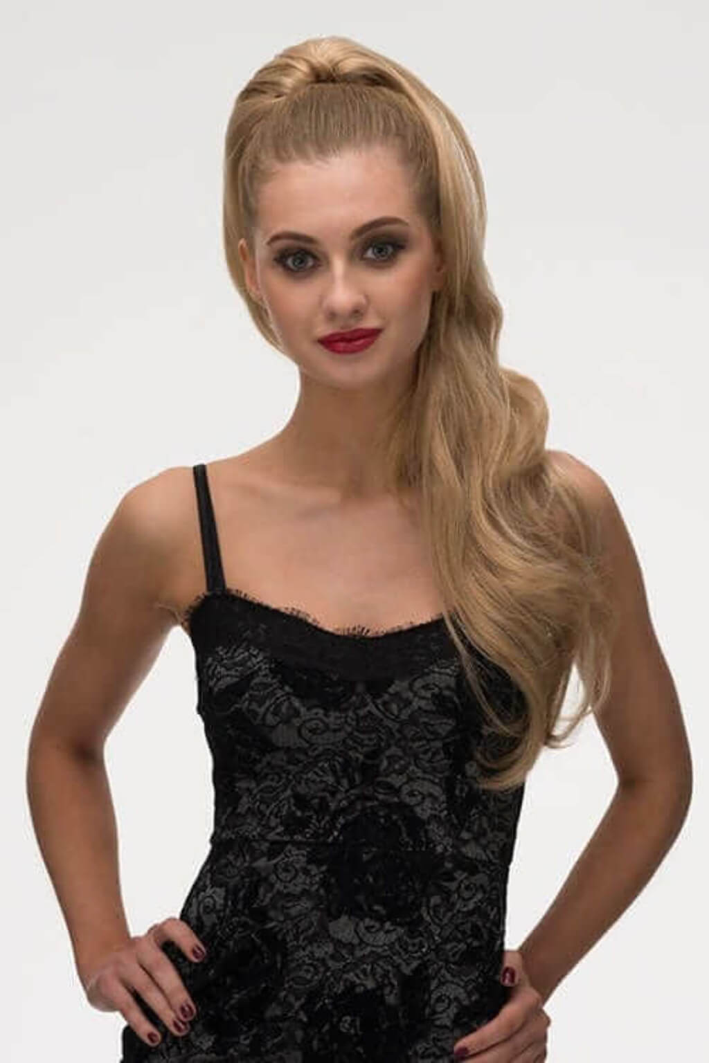 Woman with long hair wearing a black lace dress against a white background. Clip-in ponytail hairpiece extension: Olivia