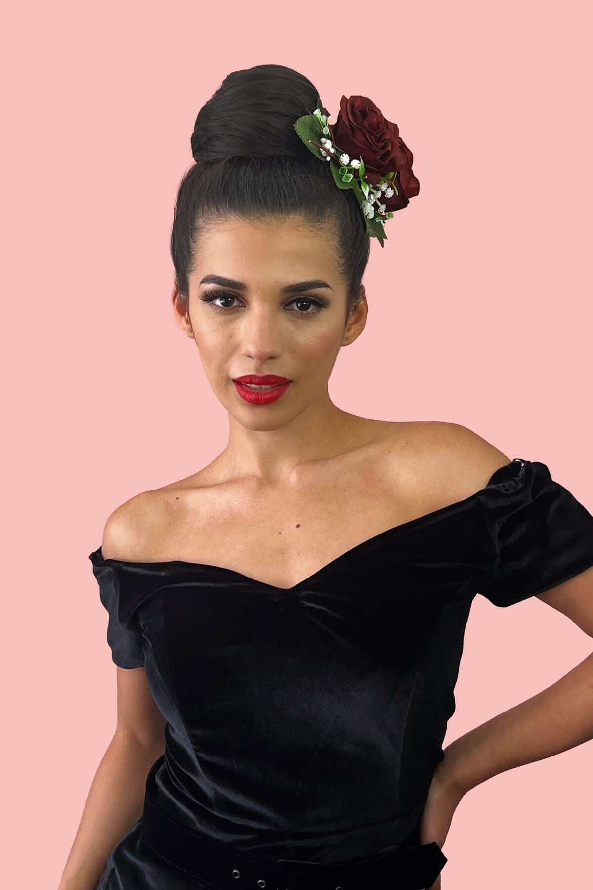 Woman wearing a black off-shoulder dress with a floral headpiece against a pink background. Hairpiece bun; instant perfect bun hairpiece: Hepburn dark brown 4
