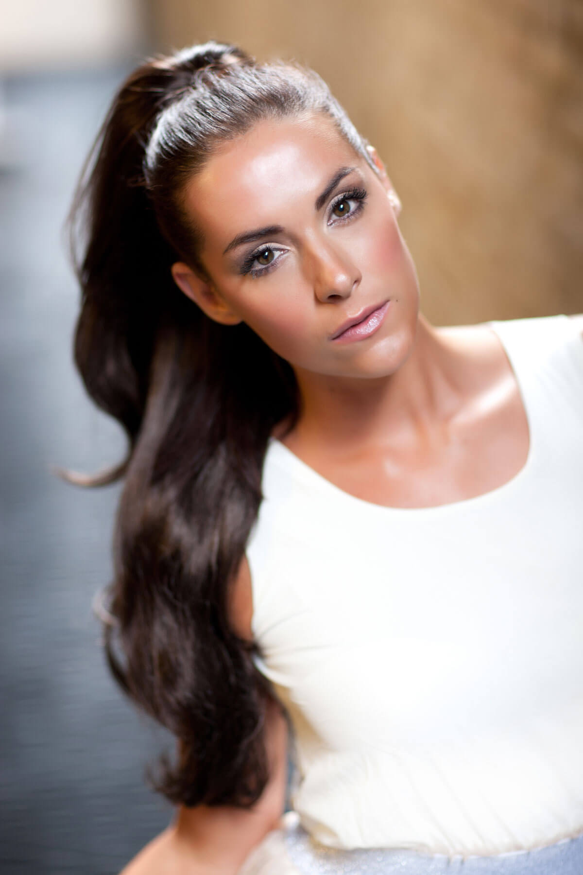 Woman with long dark hair styled in a half-up, half-down style against a blurred background. Clip-in ponytail hair piece extension, flexihair: Poppy chestnut brown 8