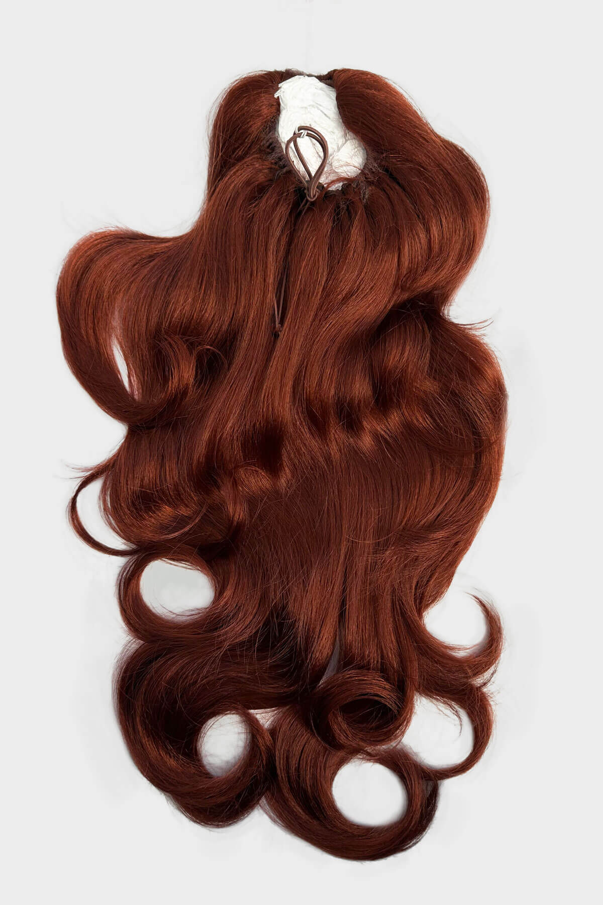 Reddish-brown hair extension on a white background. Double volume hairpiece extension: Naomi copper red 130