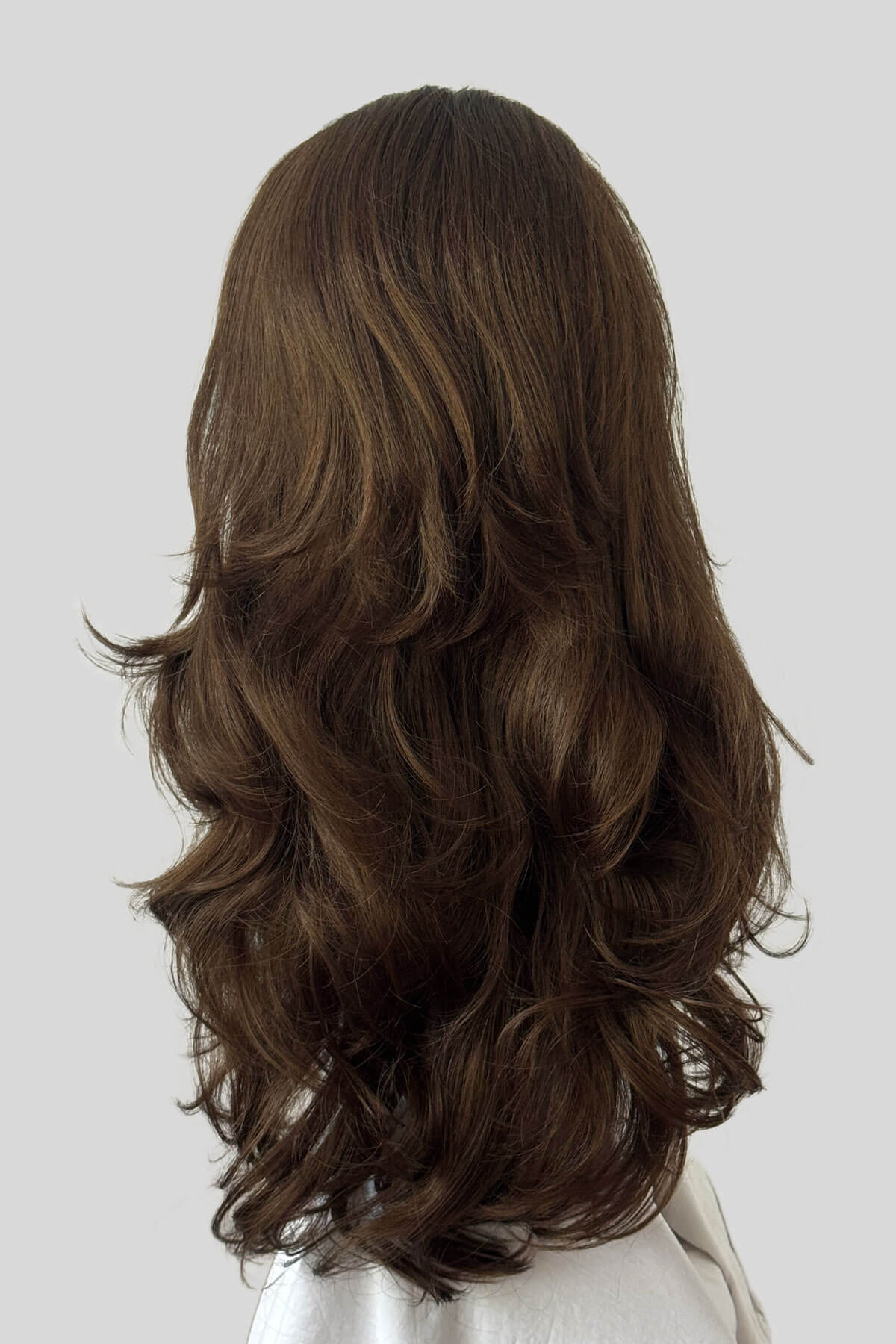 Mannequin head with long brown wig on a white background. Brown half wig hairpiece with long loose curls: Chelsea mocha brown 10