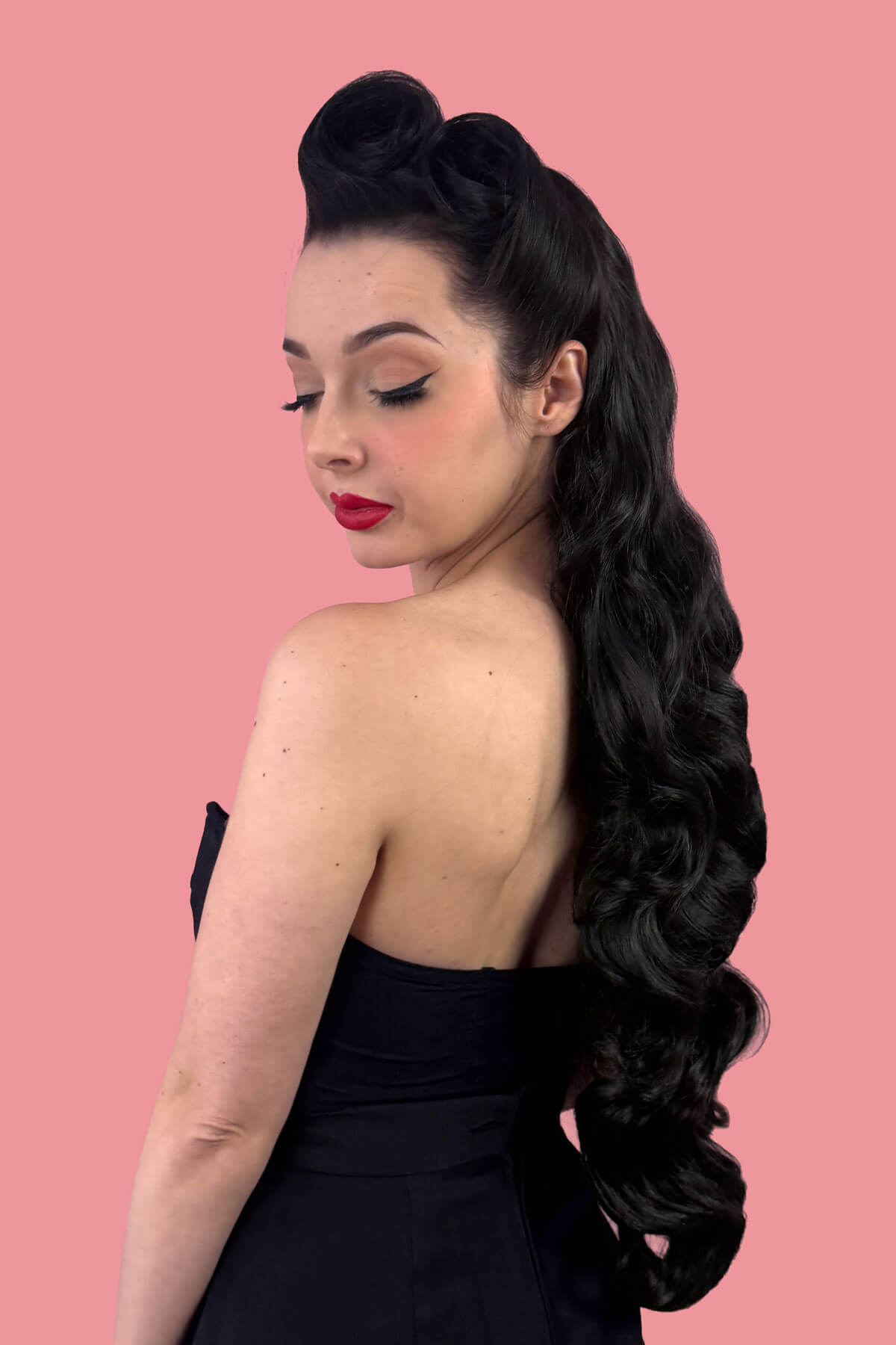 Woman with long, wavy black hair on a pink background. Ultra long half wig with hollywood waves. black 1B