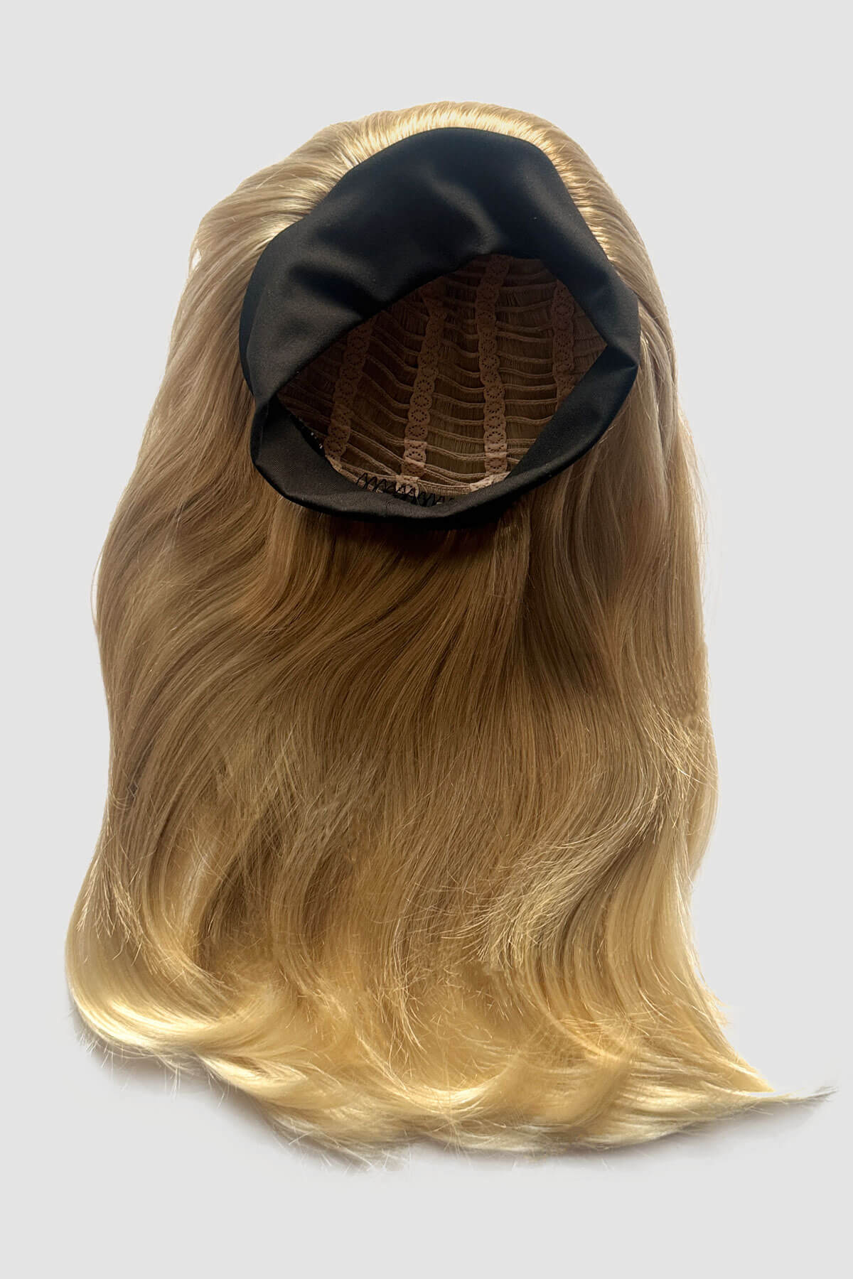 A close-up of a headband blonde half wig hairpiece showing the texture of the hair. Headband half wig hairpiece, long and straight: Isla Blonde 613T24