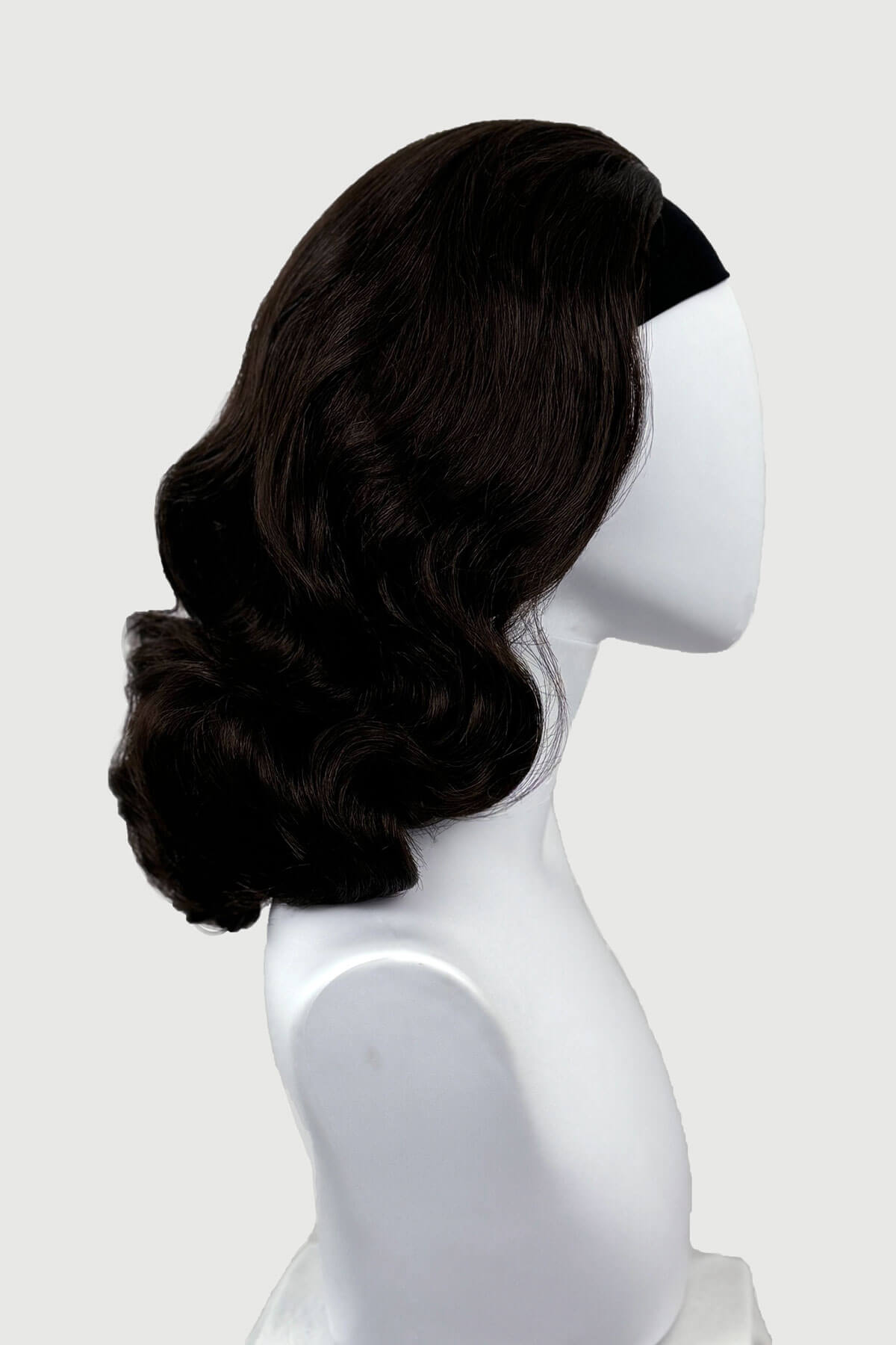 Dark chocolate brownwig on a mannequin head against a white background viewed  from the side. 1950s style shoulder length half wig hairpiece with beautiful vintage waves: Onyx dark chocolate brown 6
