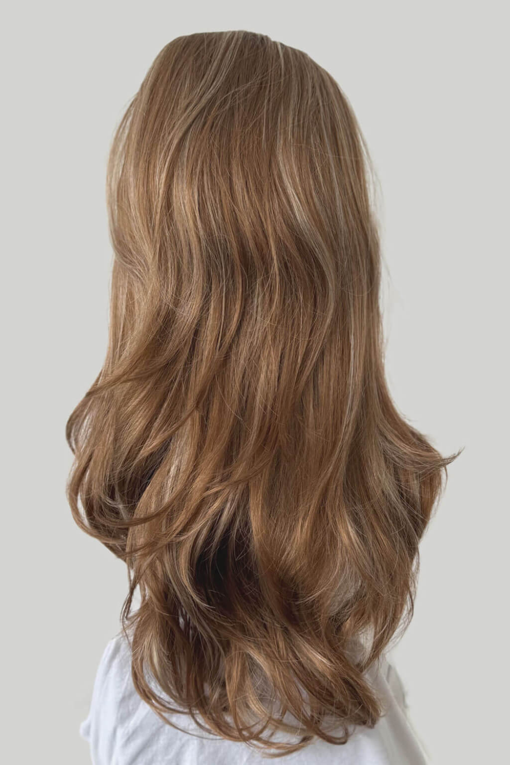 Long, wavy brown hair on a plain background. High crown long, wavy half wig and volume ring: Bardot brown blonde mix 27H613