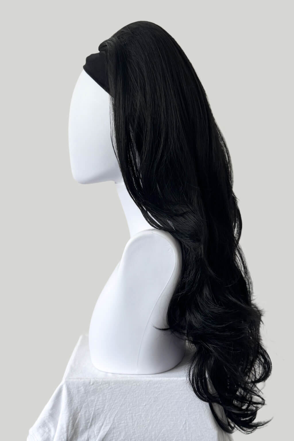 Black wig on a white mannequin head against a plain background. High crown long, layered half wig and volume ring: Helena black 1b
