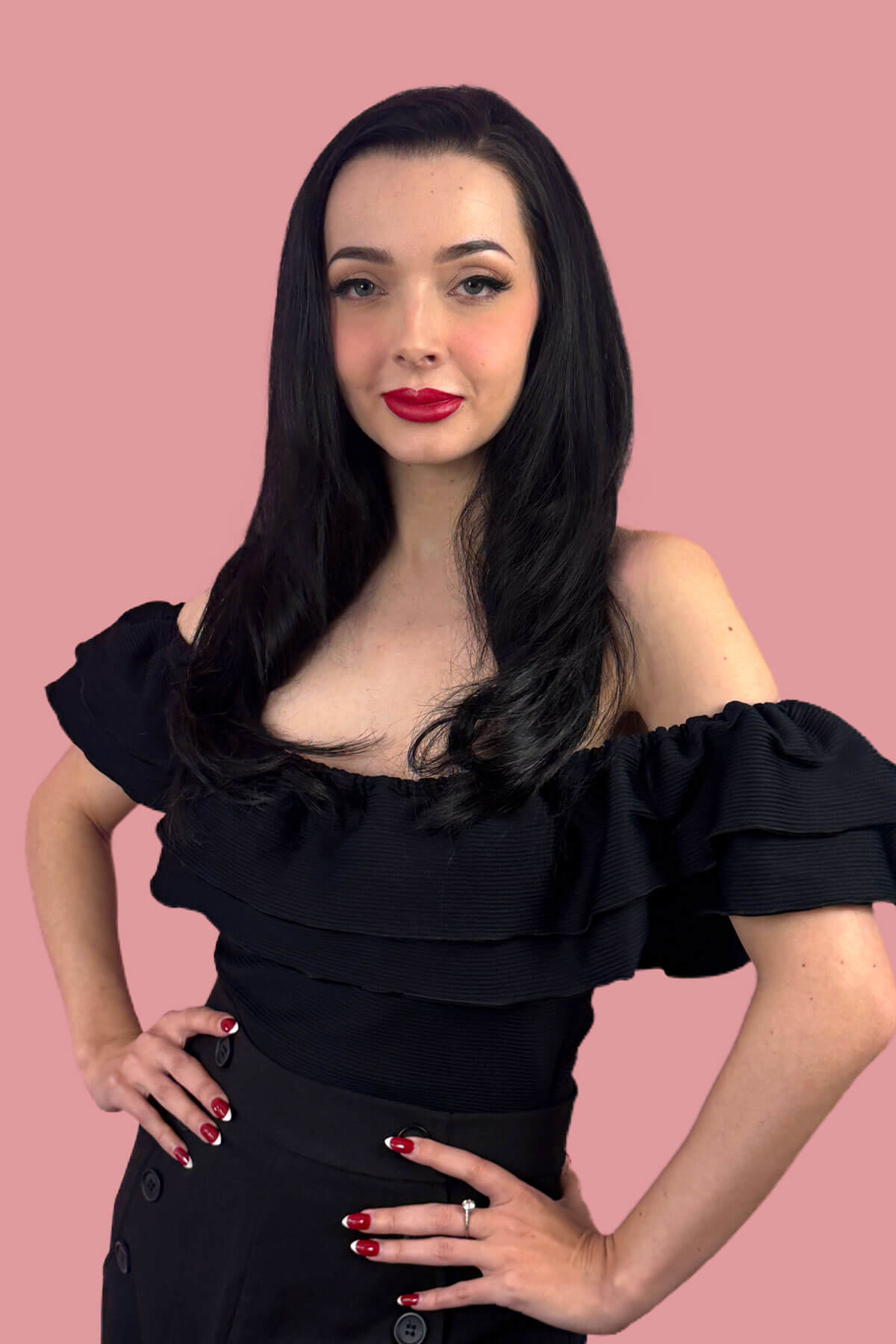 Woman with long straight black hair wearing a black off-shoulder top against a pink background. Straight black half wig hairpiece, layered: Cerys