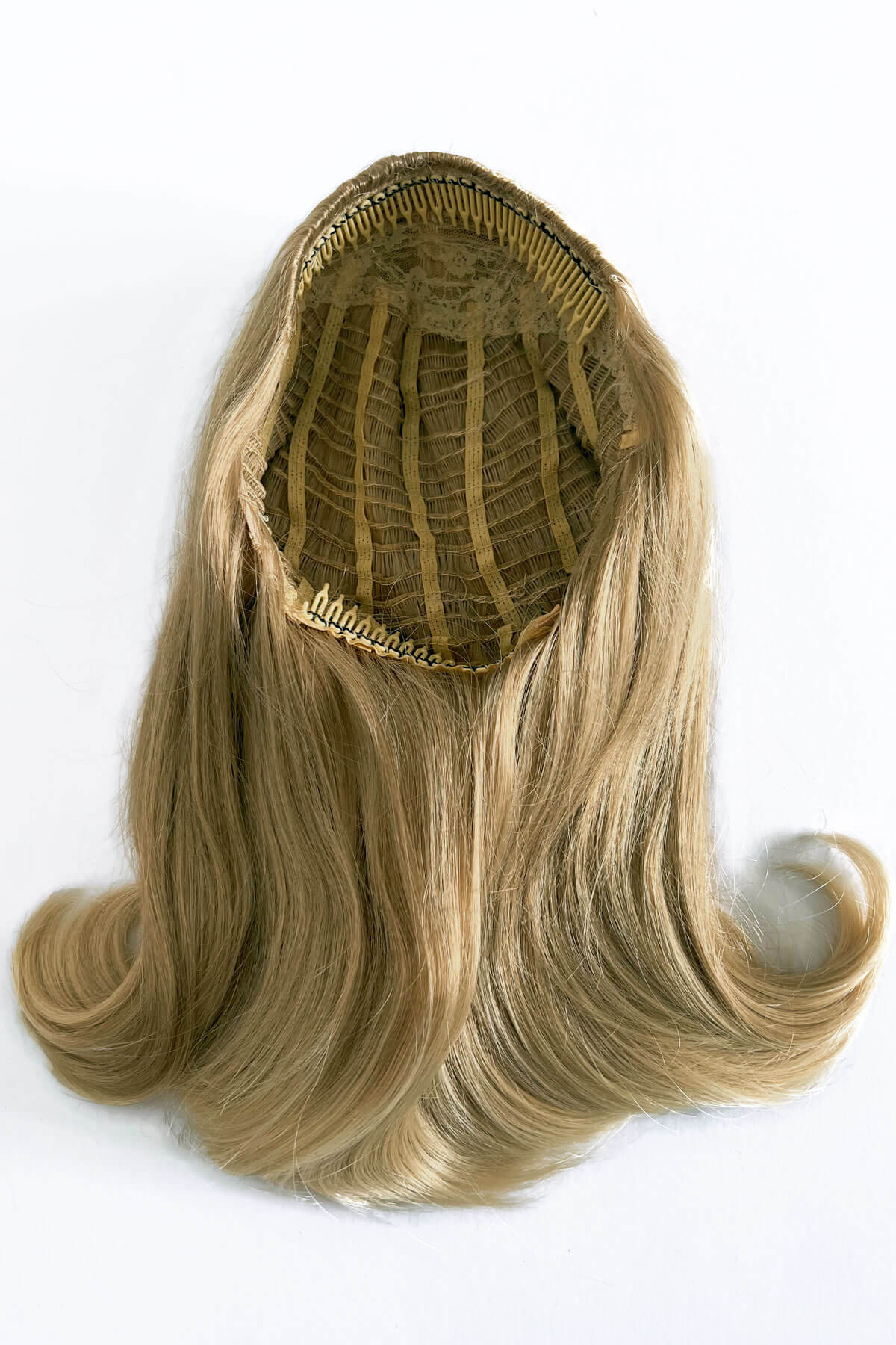 Blonde hair extension with a clip on a white background. 1960s half wig hairpiece, flicked, hair flip: Philippa blonde 613T24