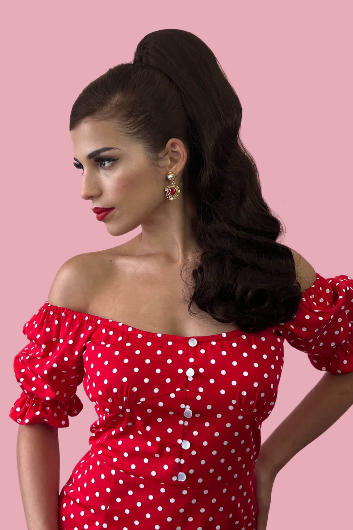 Woman wearing a red polka dot dress against a pink background.  Retro style ponytail hairpiece, long with vintage waves: Arabella  chestnut brown 8