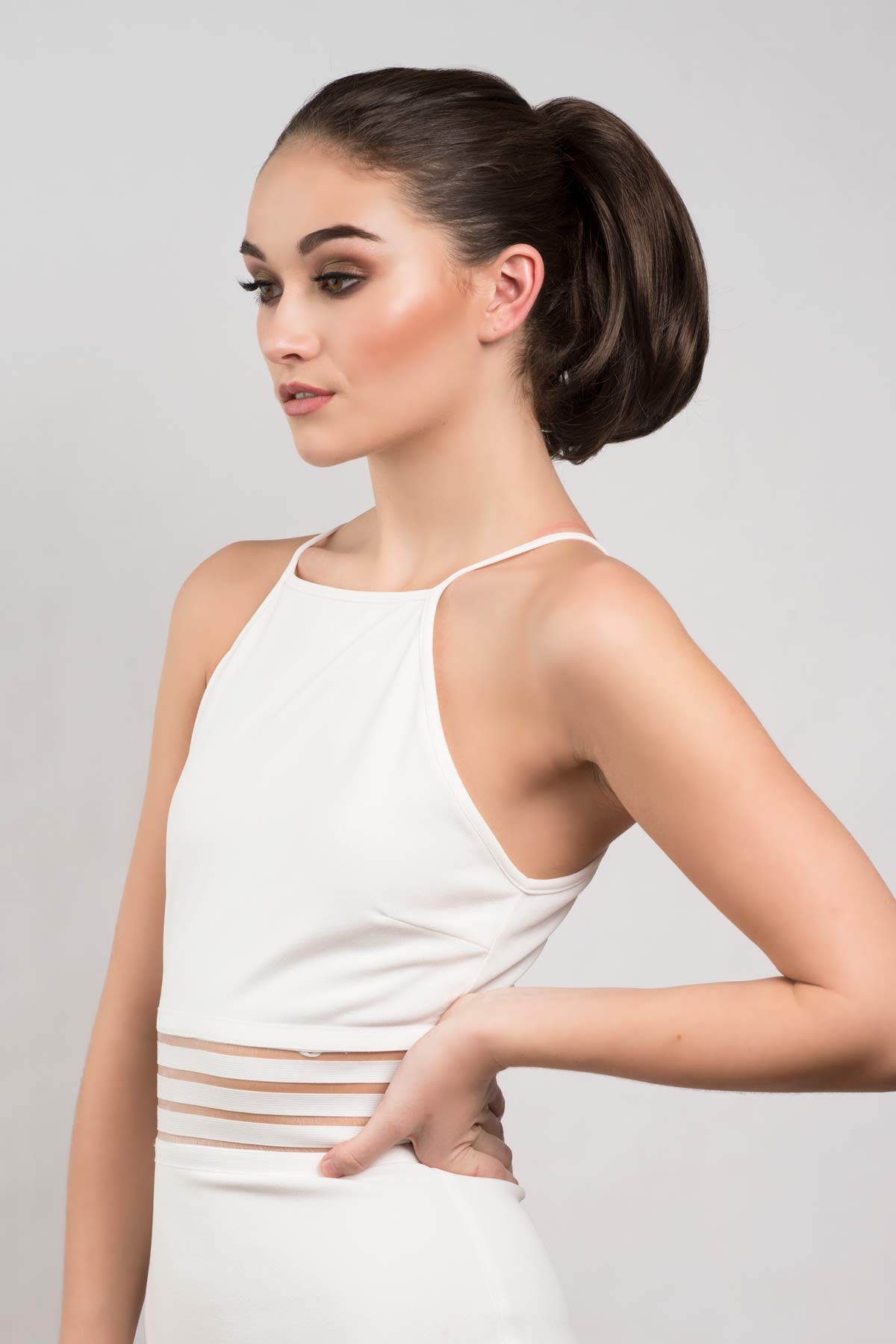 Woman wearing a white dress with thin straps against a plain background. Short ponytail extension hairpiece, straight, full & bouncy: Tanaya chestnut brown 8