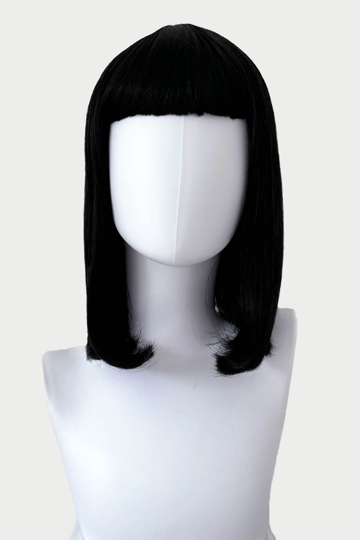 Black wig on a mannequin head against a white background. Black long bob wig with a short retro, rockabilly-style fringe: Beth