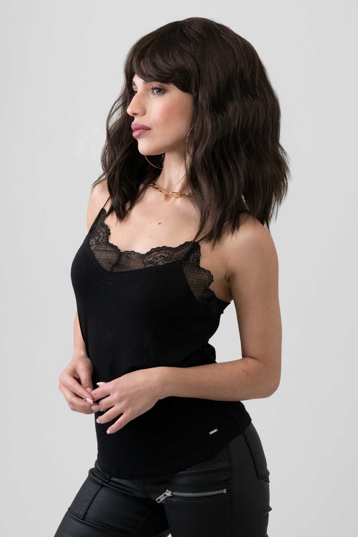 Woman wearing a black lace-trimmed top against a plain background. Dark chocolate brown long wavy bob wig: Roxy