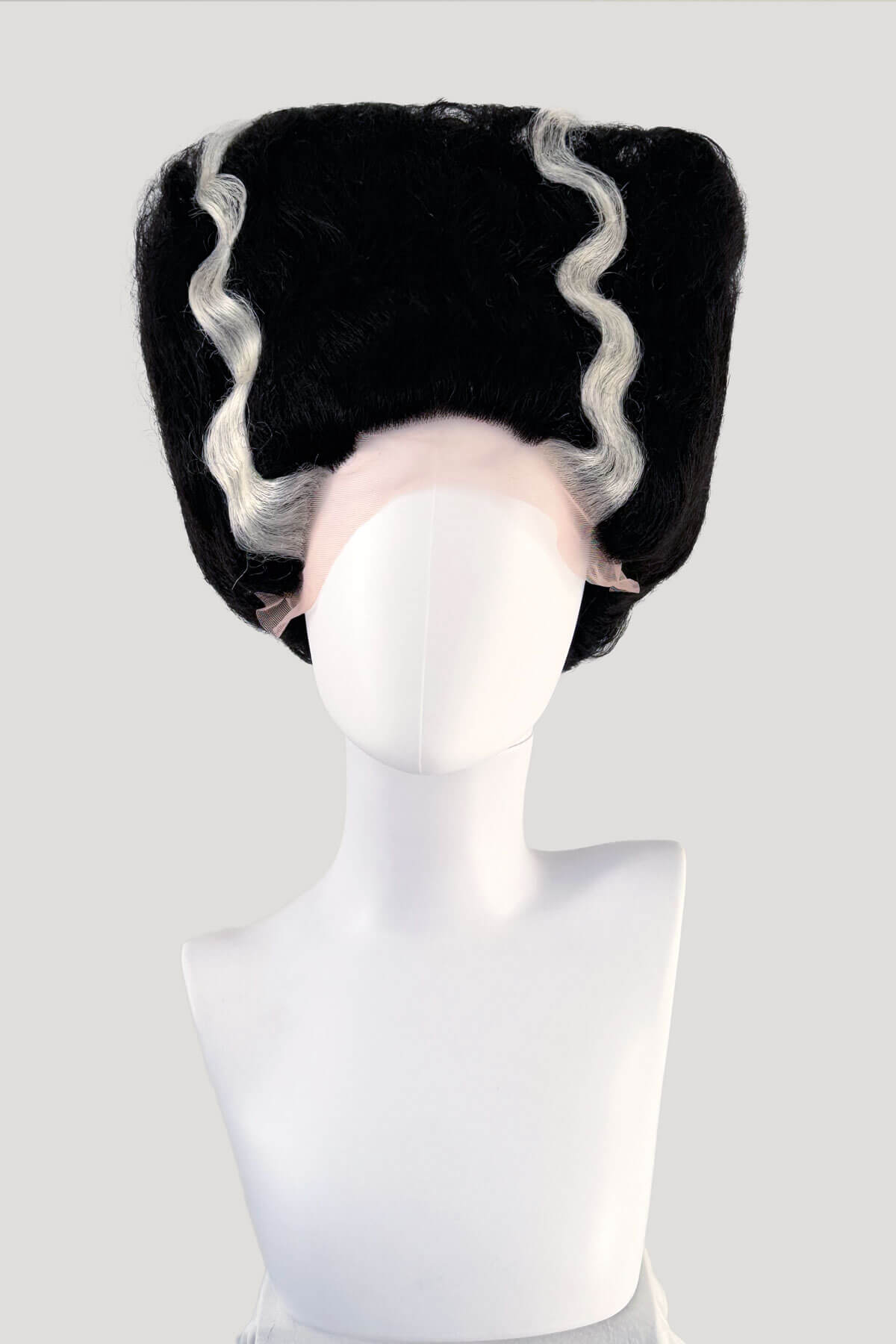 Black wig with white fringe on a mannequin head against a white background. Bride of Frankenstein lacefront wig, black with platinum streaks: Eva