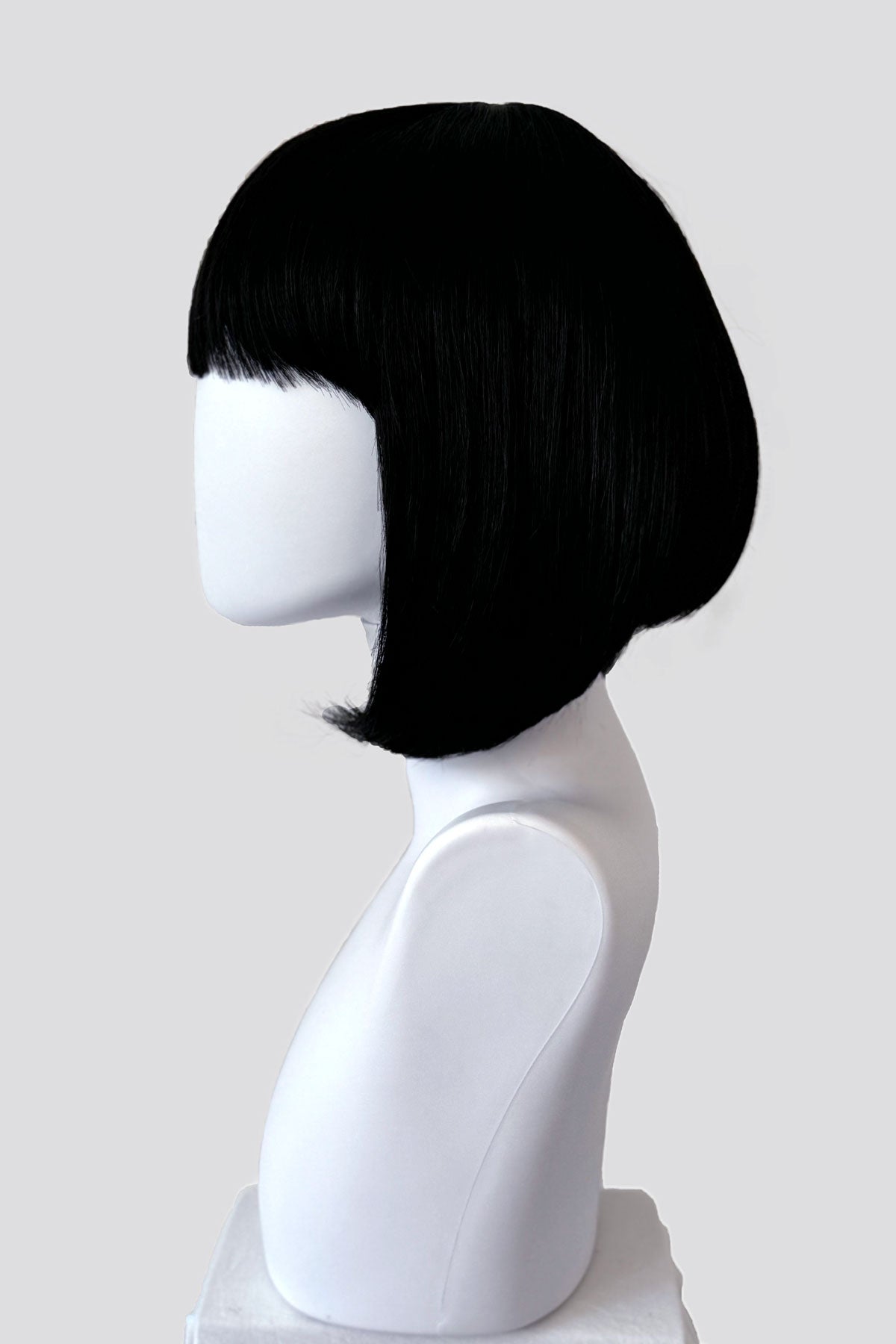 Black bob wig on a mannequin head against a white background. Black inverted bob wig: Chloe