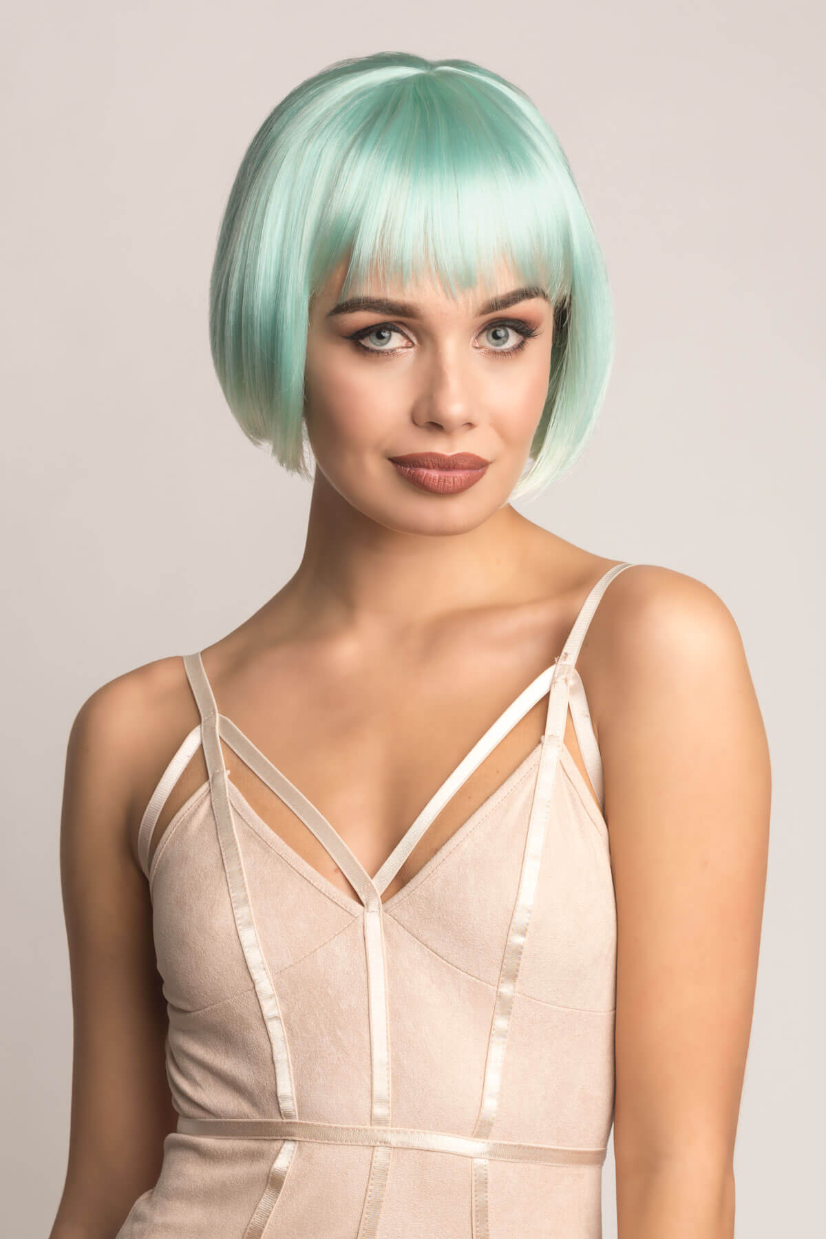 Woman with a stylish haircut and makeup against a plain background. Turquoise bob wig, with platinum blonde ombre, short and chic: Eunice